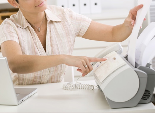 Image of a person using a fax machine on Softlinx' website