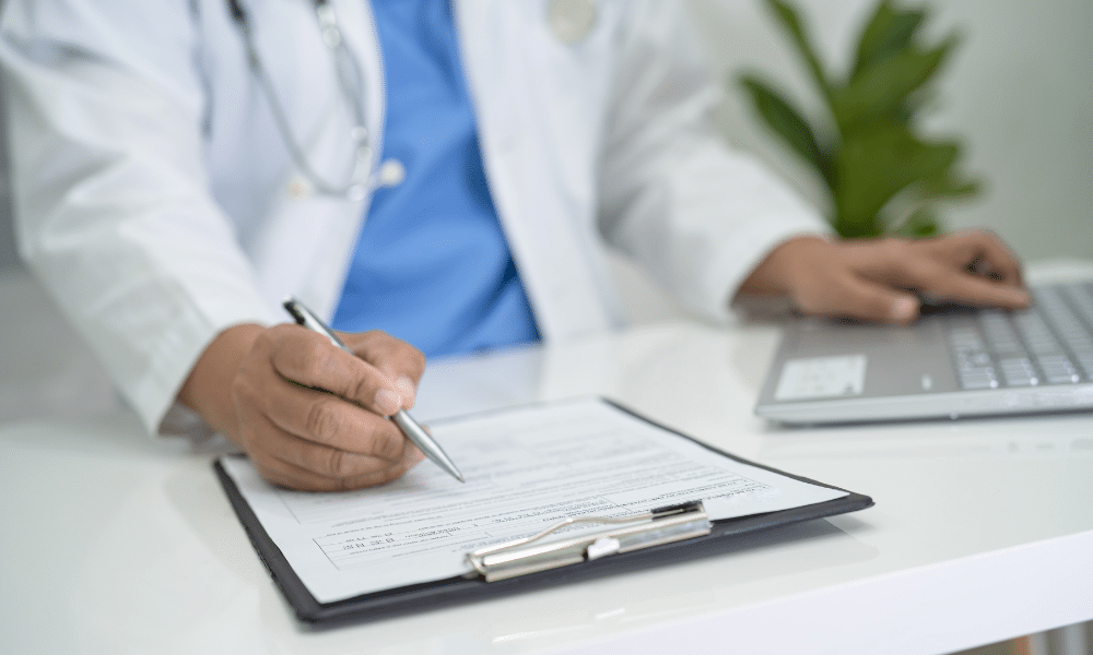 Image of a doctor writing on a document