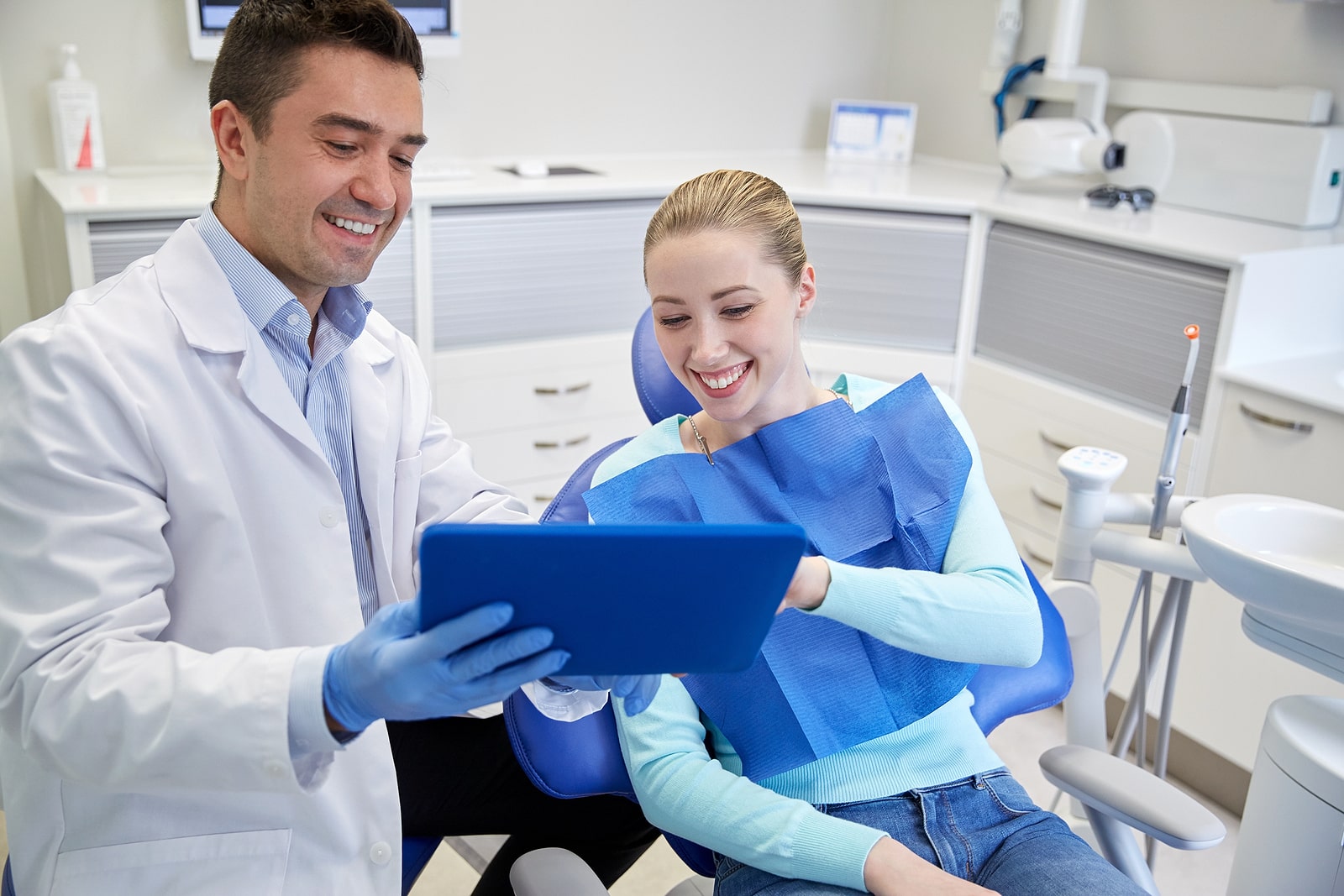 Image of a dentist showing a tablet to a patient